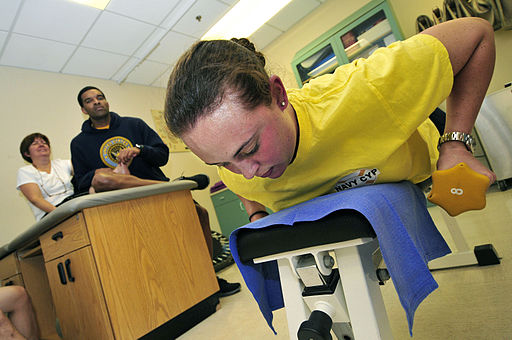 US_Navy_111102-N-IZ292-050_Operations_Specialist_1st_Class_Jennifer_Funderburk,_right,_lifts_weights_during_physical_therapy_in_the_Physical_Therap